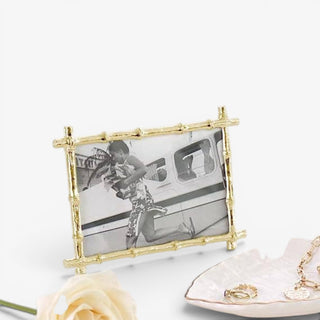 Lilly Pulitzer gold bamboo photo frame displayed on vanity table with jewelry and floral decor