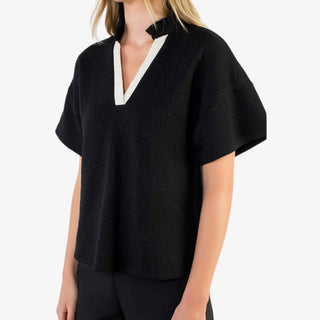 Woman wearing black contrast trim v-neck top with short wide sleeves