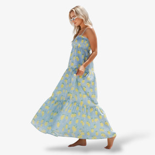 Woman wearing a blue dress with yellow floral pattern on a white background