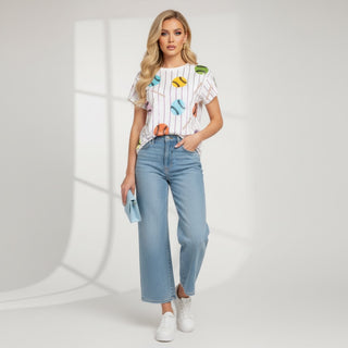 Queen of Sparkles White baseball print graphic tee styled with light wash barrel jeans, white sneakers, and a small blue clutch for a casual spring outfit