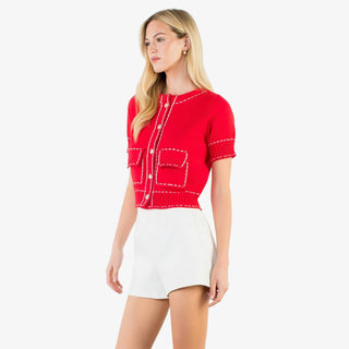 Contrast stitch knit button up top with short sleeves, decorative buttons, and tailored pockets in red or white