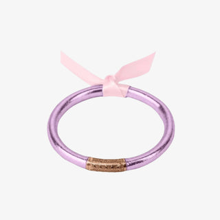A single lilac mini bangle with gold detailing in the center wrapped with a pink ribbon