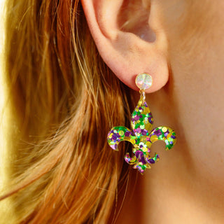 Carnival Confetti fleur-de-lis earrings with glitter-filled purple green and gold acrylic drop and iridescent crystal stud worn on model
