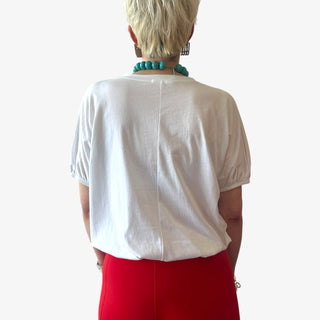 Back view of person wearing a White cotton blouse with elastic waist and sleeves on a white background