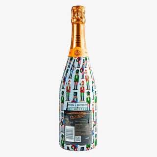 Champagne bottle wrapped in WH Hostess Nutcracker design with colorful holiday characters, fits most 750ml bottles for gifting or entertaining.