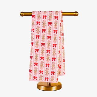 Decorative towel with red and gold patterns on a gold towel rack against a white background