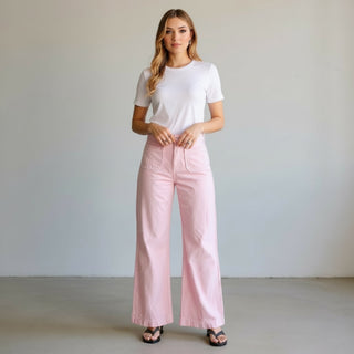 Woman wearing light pink pants with front patch pockets .