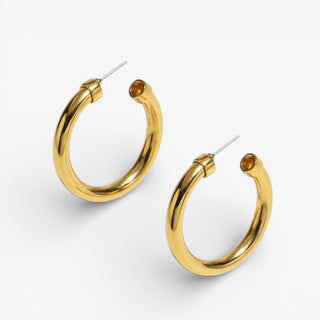 Gold Hoops with post backs on a grey background.