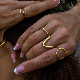Close-up of hands with gold rings on a blurred background