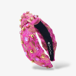 Hot pink padded headband with gold and pink jewel embellishments in a textured pattern, creating a bold, glamorous accessory for statement styling.