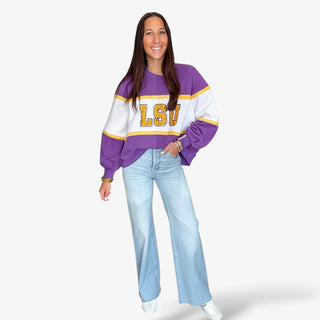 Woman wearing Queen of Sparkles LSU Jewel Sweatshirt with denim jeans and sneakers on white background 