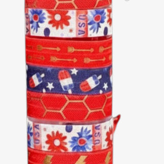 Patriotic ribbon hair ties with gold arrow print, floral USA pattern, gold honeycomb design, and red elastic bands close-up view