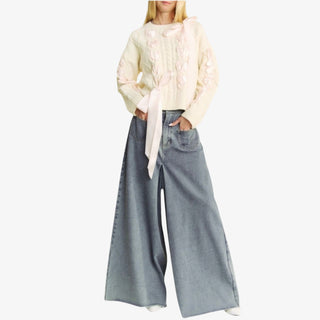 Ivory woven bow sweater with satin ribbon details and cable knit design