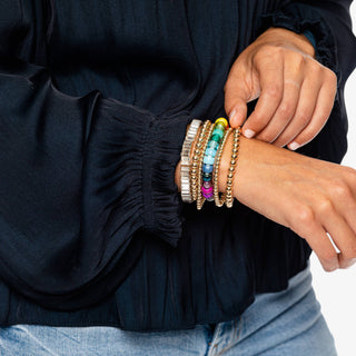 Lady wearing the baguette stretch bracelet and other multi color bracelets with a black shirt.