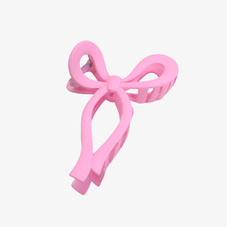 Pink bow-shaped hair clip on a white background