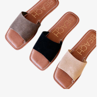 Three sandals with different colored straps on a white background