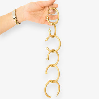 Medium Hoo Hoops brushed gold hoop earrings held in hand to show size and post closure