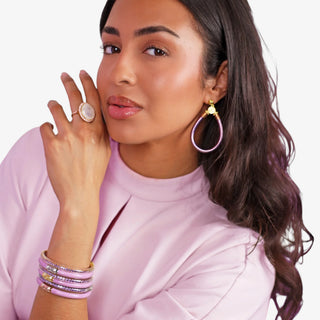Model wearing BudhaGirl All Weather Earrings Lila purple with coordinating purple and gold bracelets