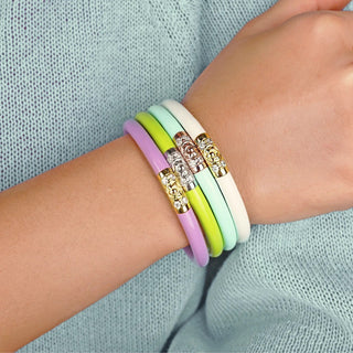BudhaGirl Bloom II bracelet stack in lavender, neon yellow, mint, and ivory with crystal floral gold and silver accents, shown stacked on wrist, front view.
