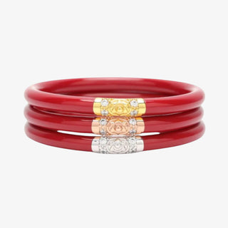 Set of red bangles with gold, silver, and rose gold accents on a white background