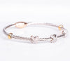 Two tone Cable X bracelet with silver cable, gold closure , X pave crystals and gold accents.
