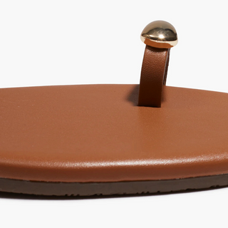 Brown sandal with a gold toe post on a white background