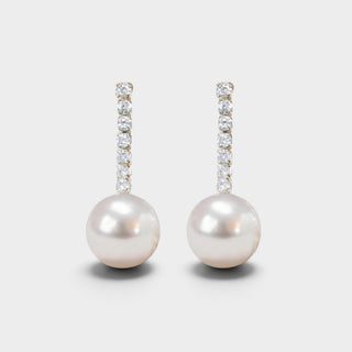 White pearl drop earrings with vertical sparkling clear crystals in gold-tone settings, front view on light gray background, elegant jewelry for weddings.