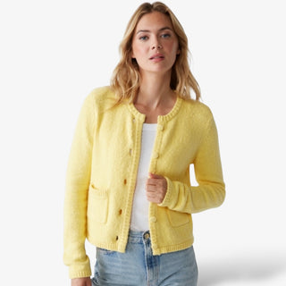 Soft yellow button-front cardigan with textured knit fabric, front pockets, and a classic crew neckline, styled casually with a white tank and denim jeans.