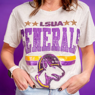 Person wearing a grey t-shirt with purple LSUA Generals text and graphics on a purple background with rhinestones