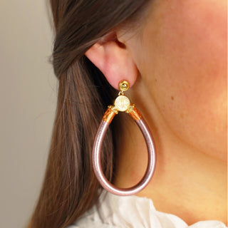 BudhaGirl Champagne All Weather Earrings worn on ear with blush champagne shimmer finish and gold accents side view