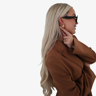 Small oval hoop earrings in 18K gold plated stainless steel with polished gold finish on neutral background