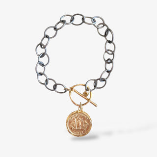 Silver link bracelet with Victorian gold coin on a grey background.