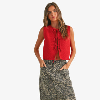 Model wearing the Scarlett Textured Tie Front Top in bright red with three front ties and a sleeveless fit, styled with a leopard print skirt.