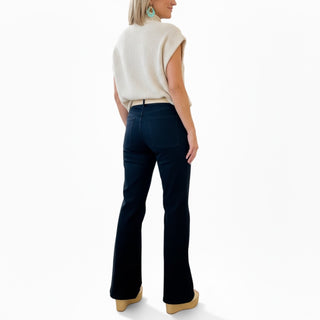 Woman wearing black flared jeans on a white background
