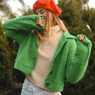 Person wearing a green fleece jacket and red beanie outdoors