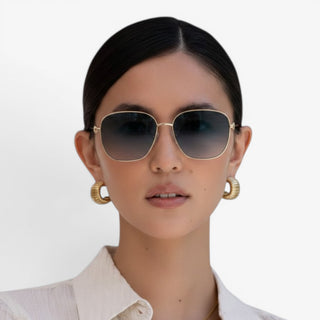 FREYRS Lea gold frame sunglasses with gray gradient lenses on model front-facing lifestyle view