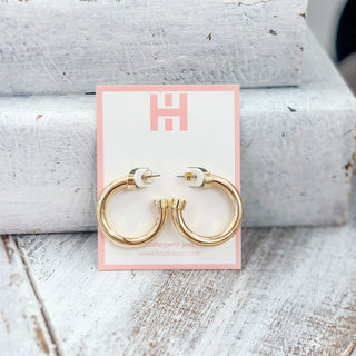 Hoo Hoops gold hoop earrings small size with polished chunky acrylic finish on pink jewelry display card front view