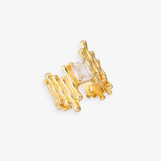 Gold ring with a central clear gemstone on a white background