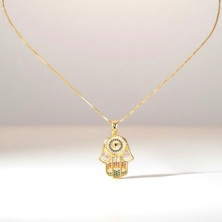 Gold chain necklace with a colorful Hamsa hand pendant on a light background