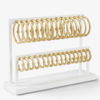 Medium Hoo Hoops brushed gold hoop earrings displayed on a white jewelry stand