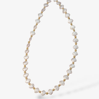 Seashell design pearlized necklace with gold accents on a white background