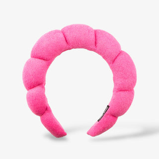 Bright pink puffy Spa Headband on a grey background