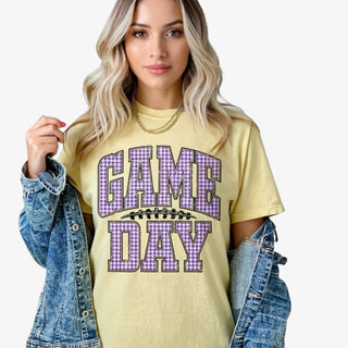 Lady wearing yellow tshirt with gingham purple and white GameDay letters