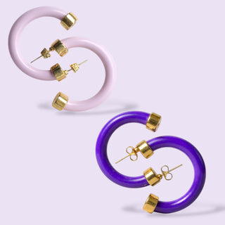 Purple and lavender hoop earrings with gold accents on a light purple background