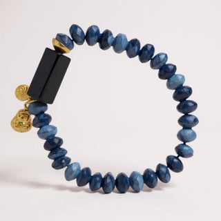 Blue beaded bracelet with deep navy  and gold accents on a light gray background