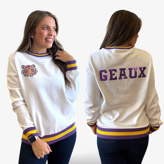 Woman wearing a white sweater with a tiger logo on the front and 'GEaux' on the back, facing both front and back.