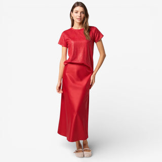 Woman wearing a red midi skirt and top on a white background