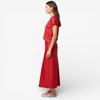 Woman wearing a red midi skirt and top on a white background