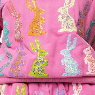 Pink sweatshirt with colorful sequined bunnies throughout the entire shirt. 