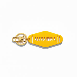 Yellow keychain with 'ALEXANDRIA' text on a white background